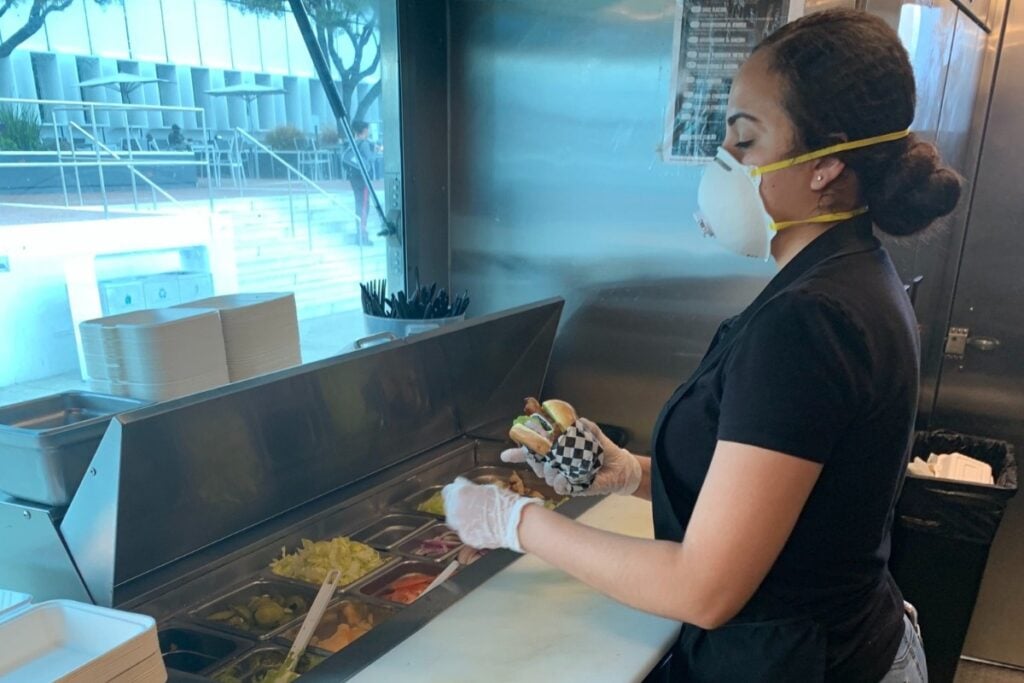 woman prepares food wearing face mask during covid-19 crisis
