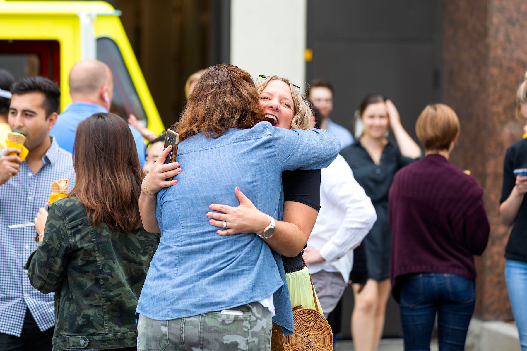 Hug-LRPhotography-RoamingHungerHearstAuto2019-55 (1) Two women hug during an ice cream employee event.